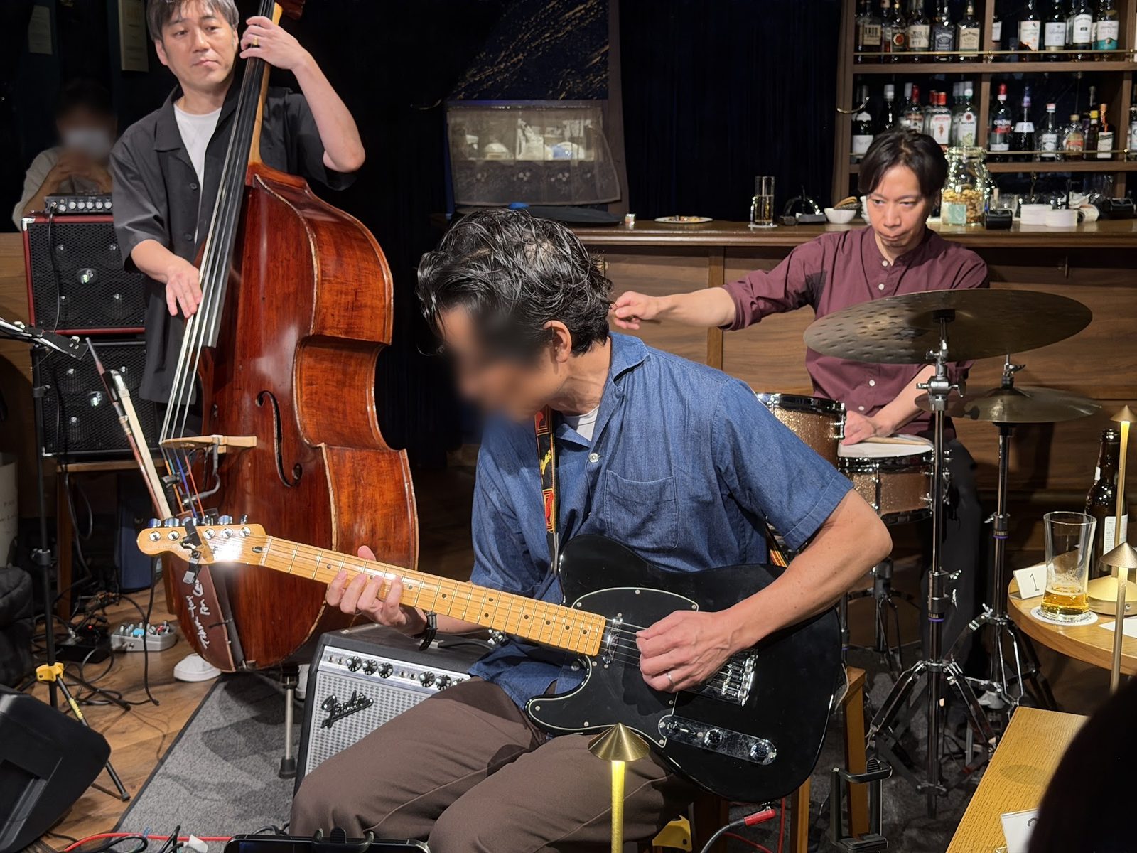 テレキャスタータイプのギターを弾く生徒さんと、後ろでプロのベーシストとドラマーがサポートするギタートリオの演奏