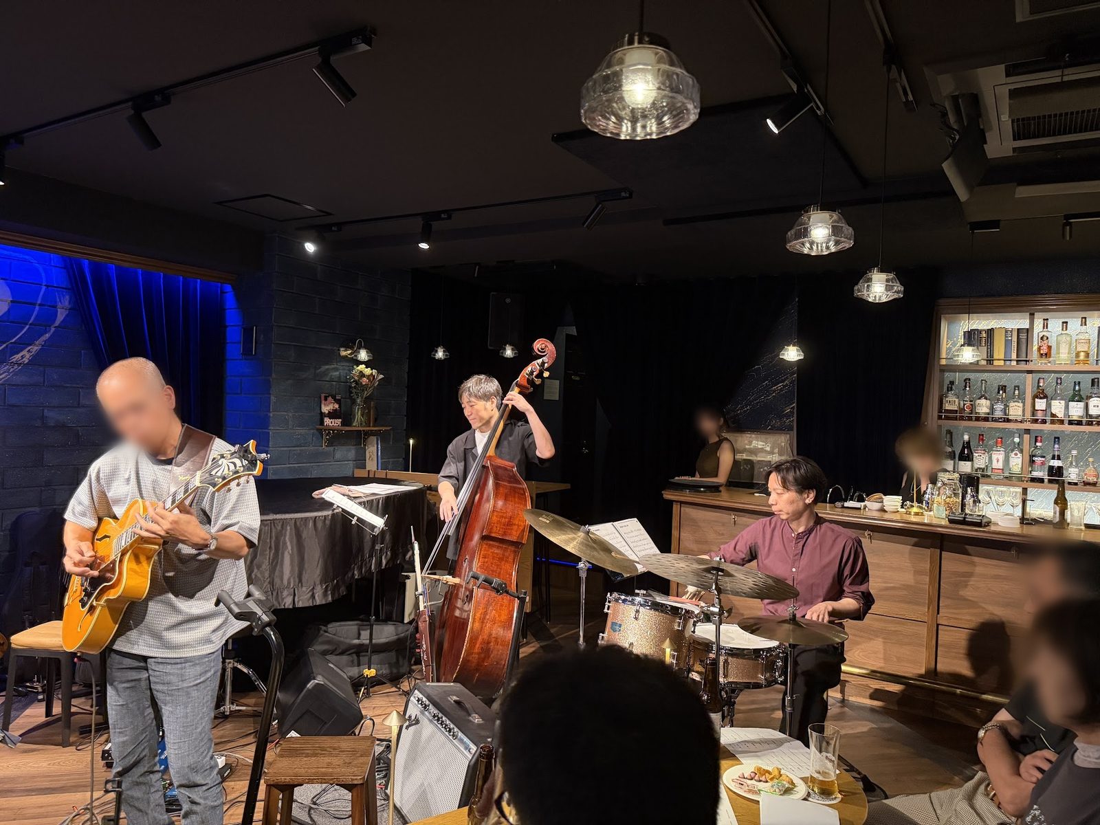 PROUST OSAKAのステージで、プロのベーシスト・ドラマーとギタートリオを演奏する生徒さん